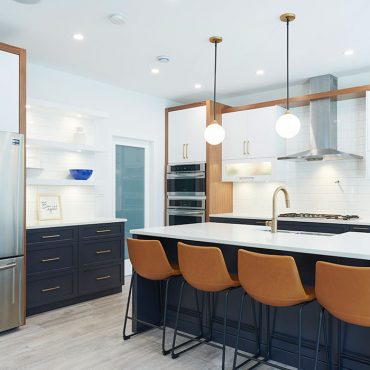 Modern kitchen with white cabinets and a navy blue island