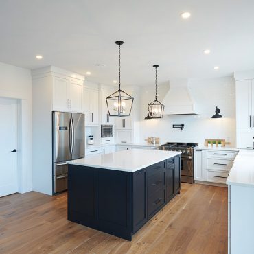 White kitchen with black cabinet island and white quartz countertops