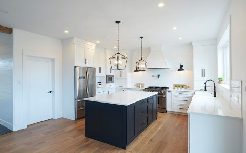 White kitchen with black cabinet island and white quartz countertops