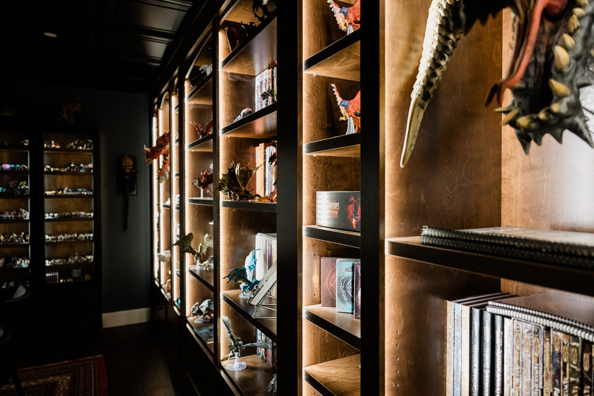 A cozy room with wooden shelving filled with fantasy-themed collectibles, books, and figurines, providing a personal touch to an enthusiast's space.