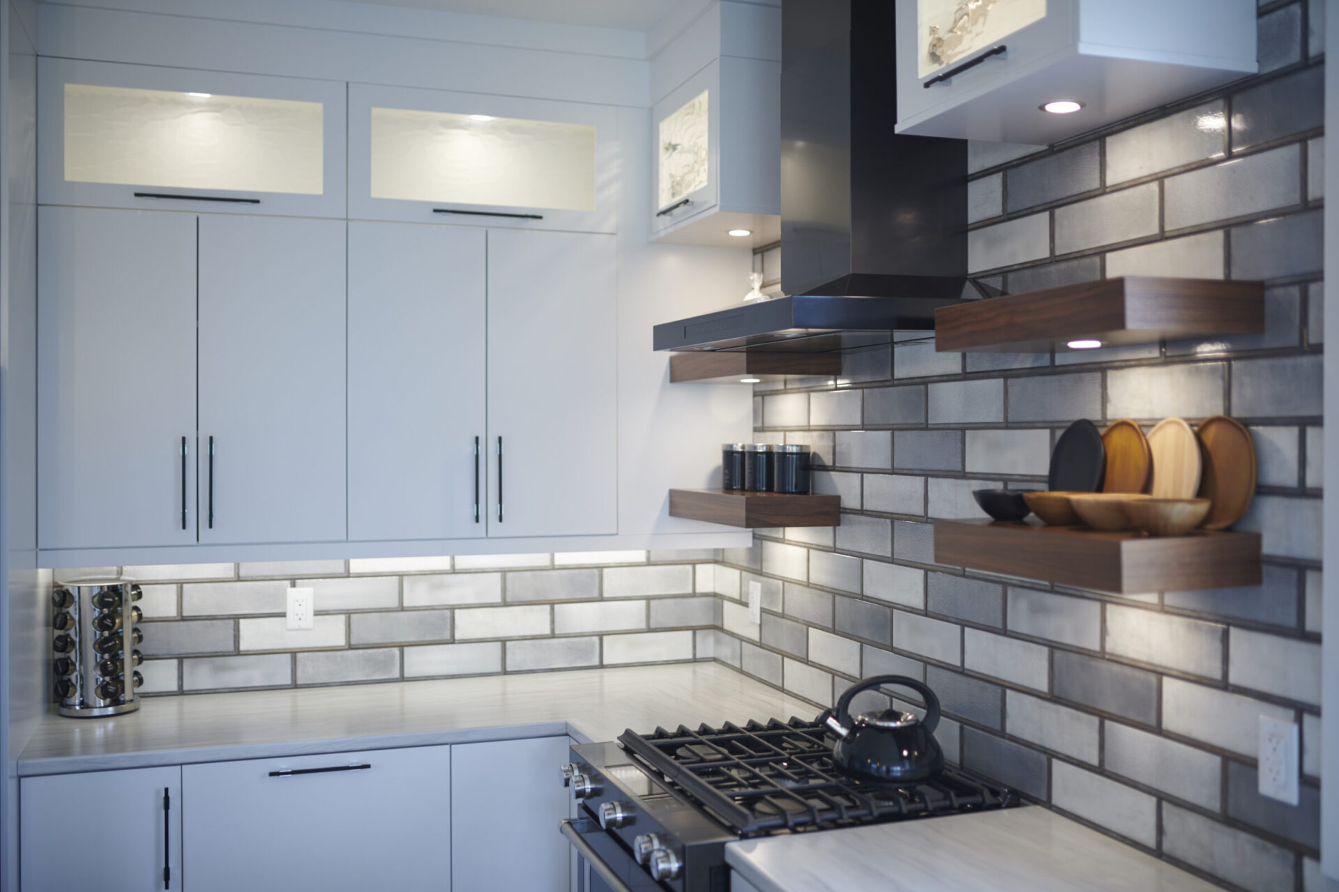 A modern kitchen interior featuring sleek gray cabinets, subway tile backsplash, stainless steel gas stove, wooden shelves, and a black vent hood.