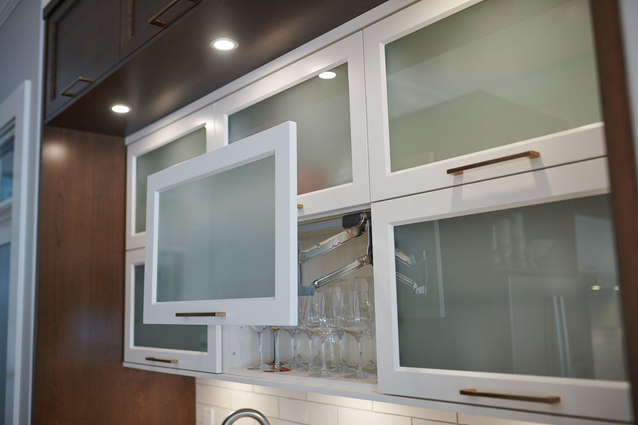 Frosted glass upper cabinets with lift-up doors and stemware storage