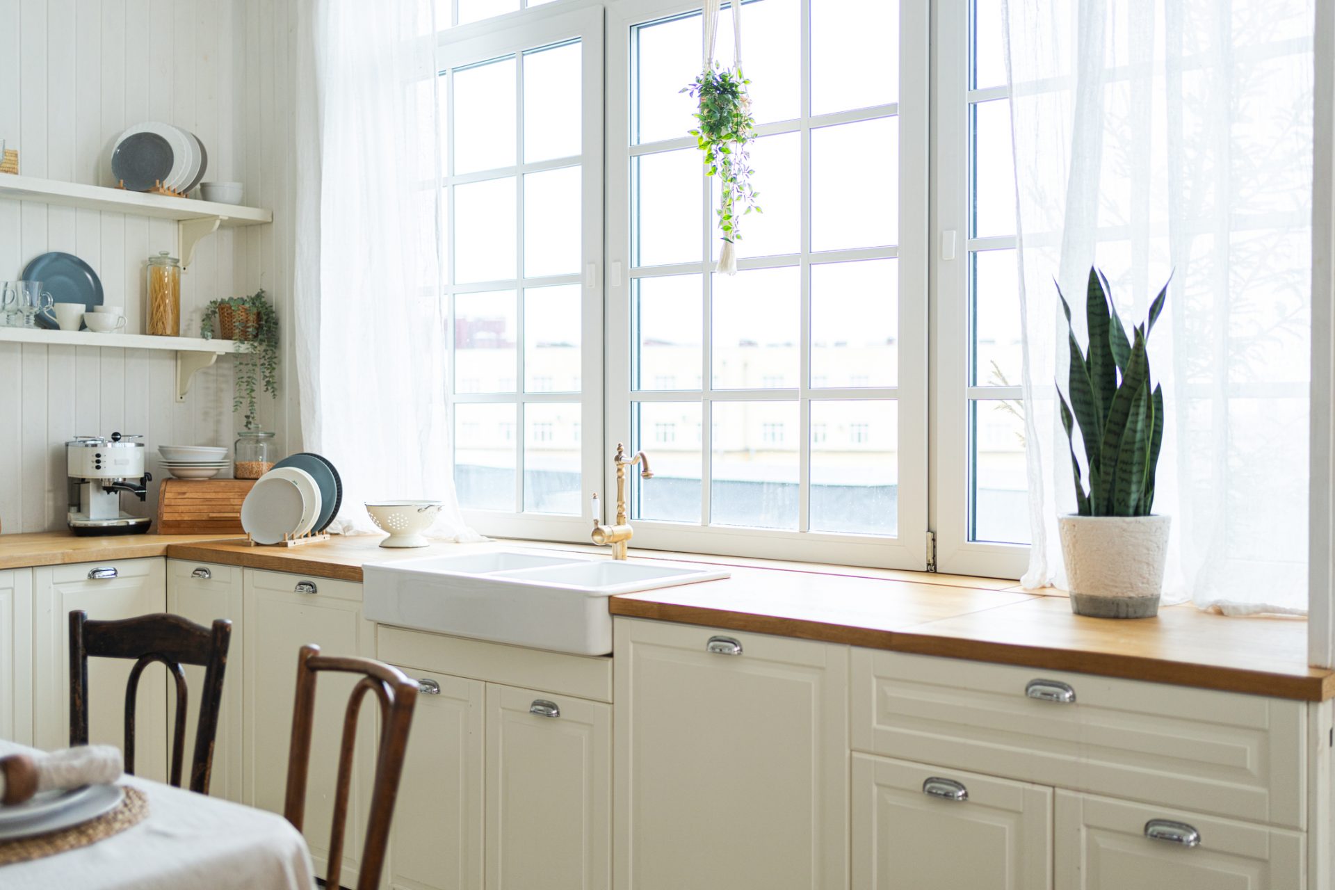 Traditional farmhouse kitchen featuring cream raised panel cabinets, a white apron sink, and butcher block countertops.